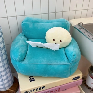 Detail of light blue plush tissue box in sofa shape with cute character on books