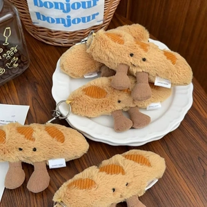 Detailed plush baguette keychain with corduroy legs displayed on a rustic ceramic plate
