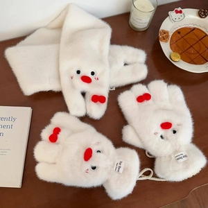 Dettaglio di sciarpa e guanti in peluche bianco con decorazioni a forma di pinguino