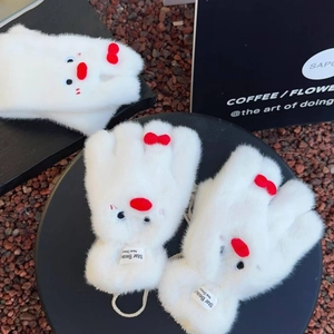 Dettaglio di guanti da pinguino in peluche bianca con fiocco rosso e cordino al collo