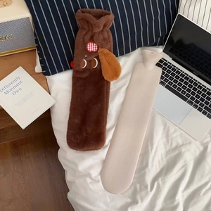 Detail of long plush dachshund dog hot water bottle with LUCKY embroidery on white bedding
