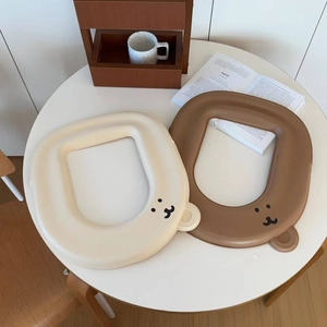 Detail of waterproof cartoon bear toilet seat pads in beige and brown colors