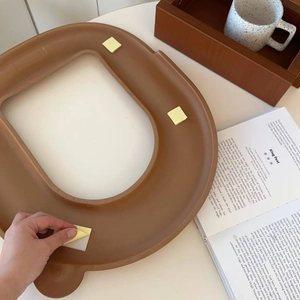 Brown U-shaped waterproof toilet seat cover with self-adhesive backing installation