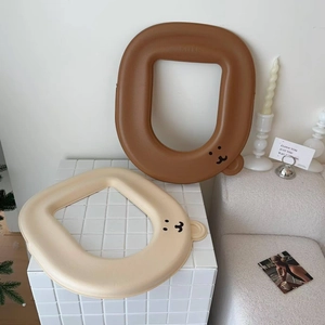 Detail of cartoon bear EVA toilet seat covers in brown and beige colors with ear design