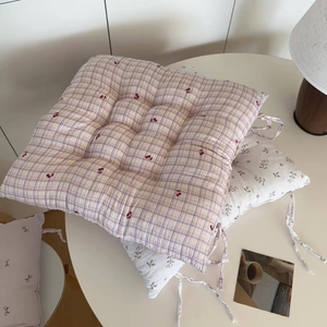 Detail of floral and checkered seat cushions with quilting and secure chair ties