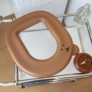 Detail of waterproof brown bear toilet seat cover with cute ears on a storage cart