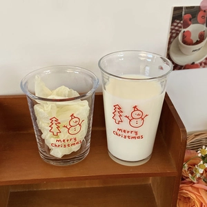 Detail of Christmas snowman glass with milk on a wooden shelf with floral decor