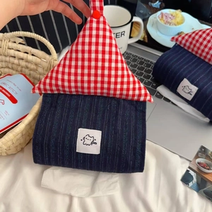 Detail of house-shaped fabric tissue box with red checkered roof and cat patch