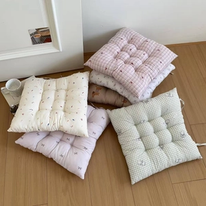Detail of floral quilted seat cushions with anti-slip ties and soft cotton-linen texture