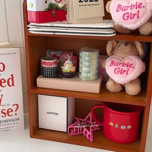 Pink star-shaped hair claw clip with rhinestones on a multi-tier wooden desktop shelf