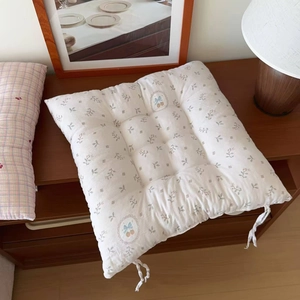 Detail of floral quilted seat cushion with corner ties and cherry bow emblem design