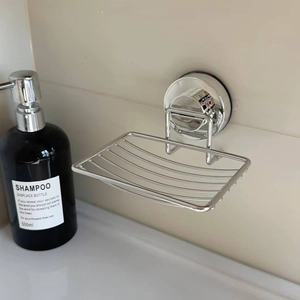 Detail of wall-mounted stainless steel soap dish with suction cup on bathroom tile