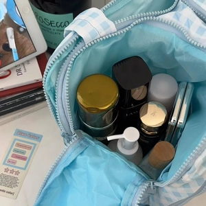 Blue checkered makeup bag detail showing spacious interior storage and zipper closure