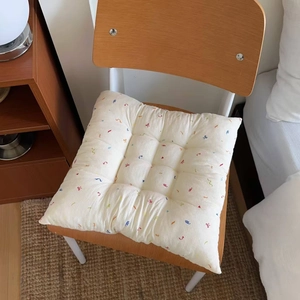 Detail of floral quilted seat cushion showing thick texture and colorful embroidery