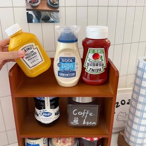 Detail of wooden multi-tier organizer rack filled with various kitchen sauce bottles