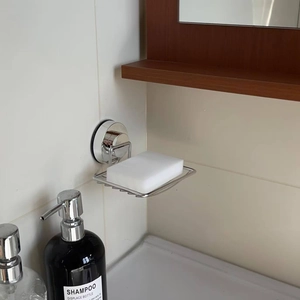 Close-up of wall-mounted stainless steel mesh soap dish with vacuum suction cup base
