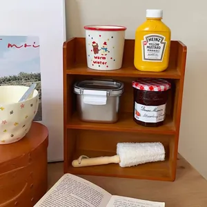 Detail of multi-tier wooden desktop shelf with ceramic cups and cleaning brush in warm light