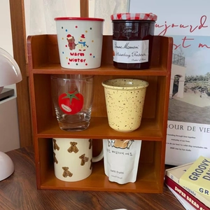 Detail of a 3-tier reddish-brown wooden desktop shelf showing natural wood grain texture