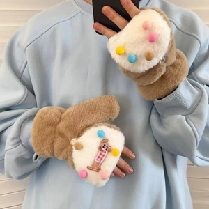 Detail of plush winter flip-top gloves with colorful pom-poms and cartoon dog embroidery
