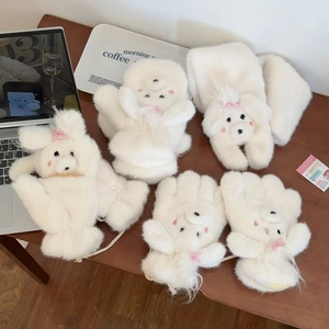 Close-up of white plush dog-themed gloves and scarf set with pink bow details