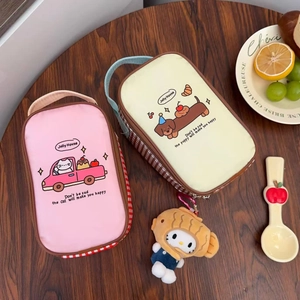 Close-up of insulated lunch bags with dog and cat patterns on a wooden desk