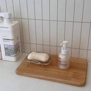 Close-up of stainless steel wire soap dish with wall suction cup in modern bathroom setting