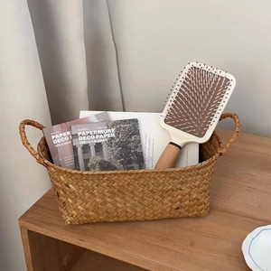 Close-up of a white square paddle brush with wood grain handle in a woven basket