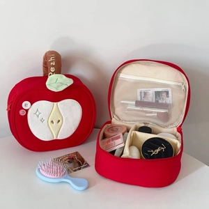 Internal view of apple-shaped makeup bag showing adjustable dividers and mesh pocket