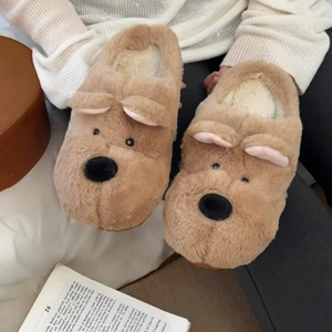 Detalle de pantuflas de perro de peluche con orejas suaves y forro polar muy cálido