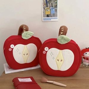 Cute apple-shaped makeup bag in red fabric with plush details and convenient top handle