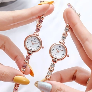Close-up of rose gold heart-shaped quartz watches with pink and white rhinestones