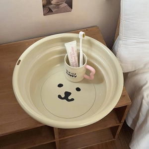 Close-up of a cream bear foldable washbasin and mug with a pink heart handle