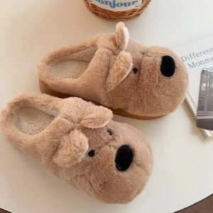 Detalle de zapatillas de perro de felpa marrón con suela gruesa y textura suave