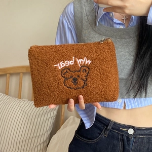 Detail of teddy fleece cosmetic bag with cute bear embroidery and top zipper closure