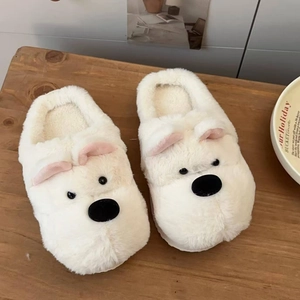 Primer plano de pantuflas de peluche Westie blanco con pelo grueso en mesa de madera