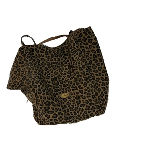 Fashionable leopard print canvas tote bag with metal handmade tag on white background