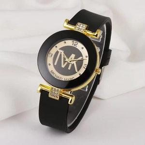 Detail of crystal-encrusted lugs and gold MK logo on black silicone watch dial