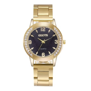 Detailed close-up of a gold-toned quartz watch with diamond bezel and black textured dial