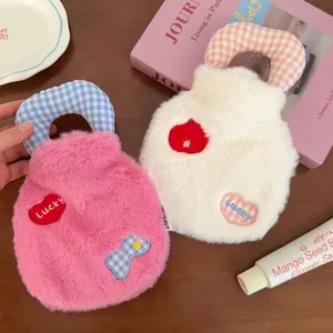 Close-up of plush hot water bottle covers in pink and white with lucky heart patches