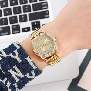 Detailed view of luxury gold women's watch with rhinestone dial and metal link bracelet