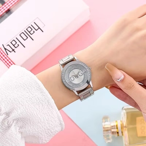 Close-up of luxury women's silver quartz watch with rhinestone bezel on wrist