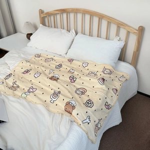 Detail view of soft coral fleece blanket with cute cartoon bear and wave edge stitching