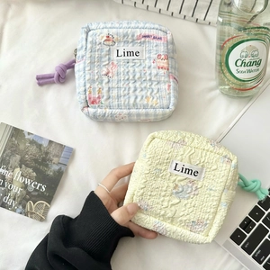 Detailed shot of quilted cotton pouches featuring lime labels and cute cartoon prints