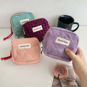Quilted plaid makeup bag set in green, red, orange, and purple with woven zipper pulls