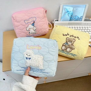 Detailed view of three quilted cotton cosmetic bags with cute animal embroidery and zippers