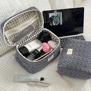 Détail d'une trousse de maquillage matelassée bleue avec poches intérieures en filet