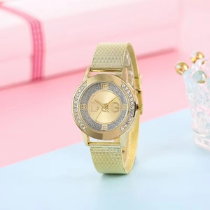 Elegant gold quartz watch with diamond-encrusted bezel and mesh band on pastel background