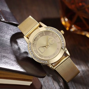 Close-up of gold mesh strap ladies watch with rhinestone bezel and metal brand logo