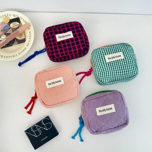 Flat lay of colorful quilted checkered makeup bags with compartments and zip closure