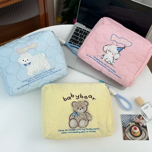 Detailed set of three quilted cosmetic bags in pastel blue, pink, and yellow colors